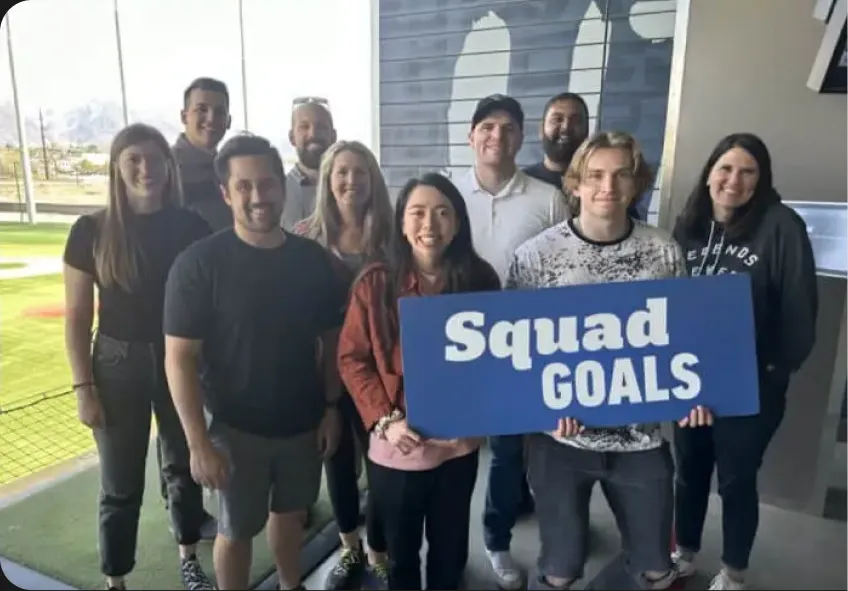 RedSky team holding a Squad Goals sign at a team outing